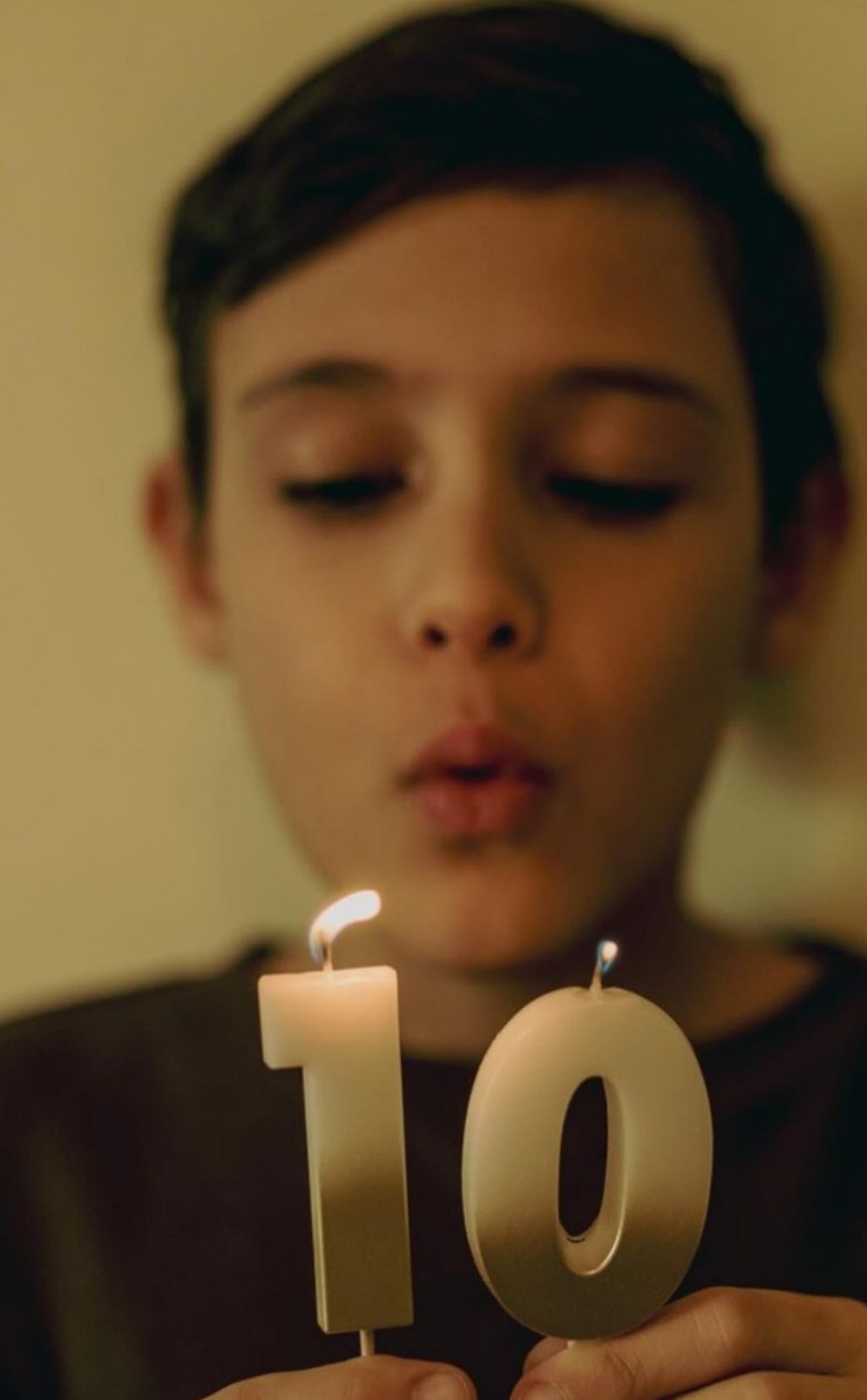 Jack Simeonov, age 10, blowing out a candle shaped like the number 10.
